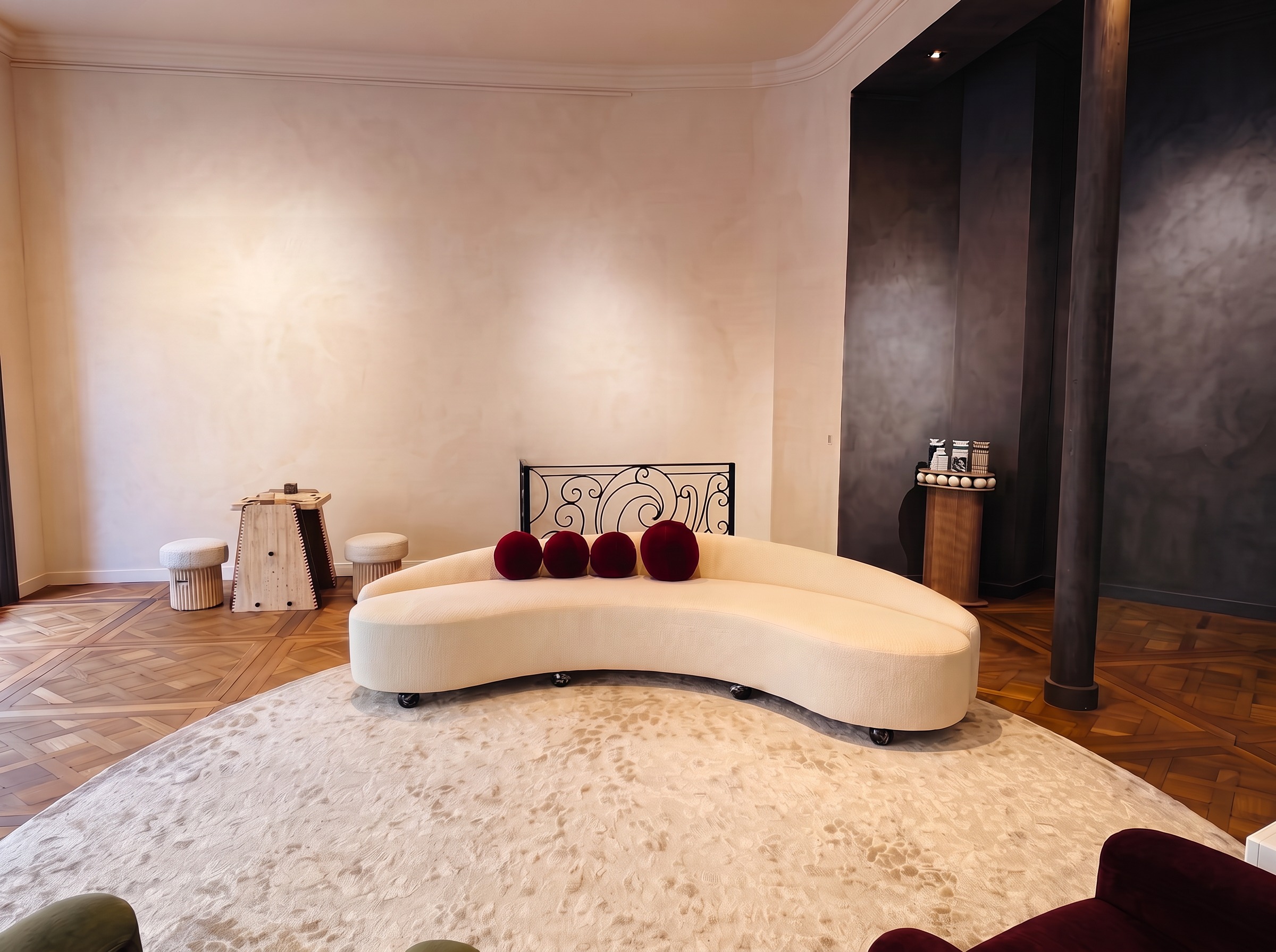 The salon and its curved ivory sofa, without artworks